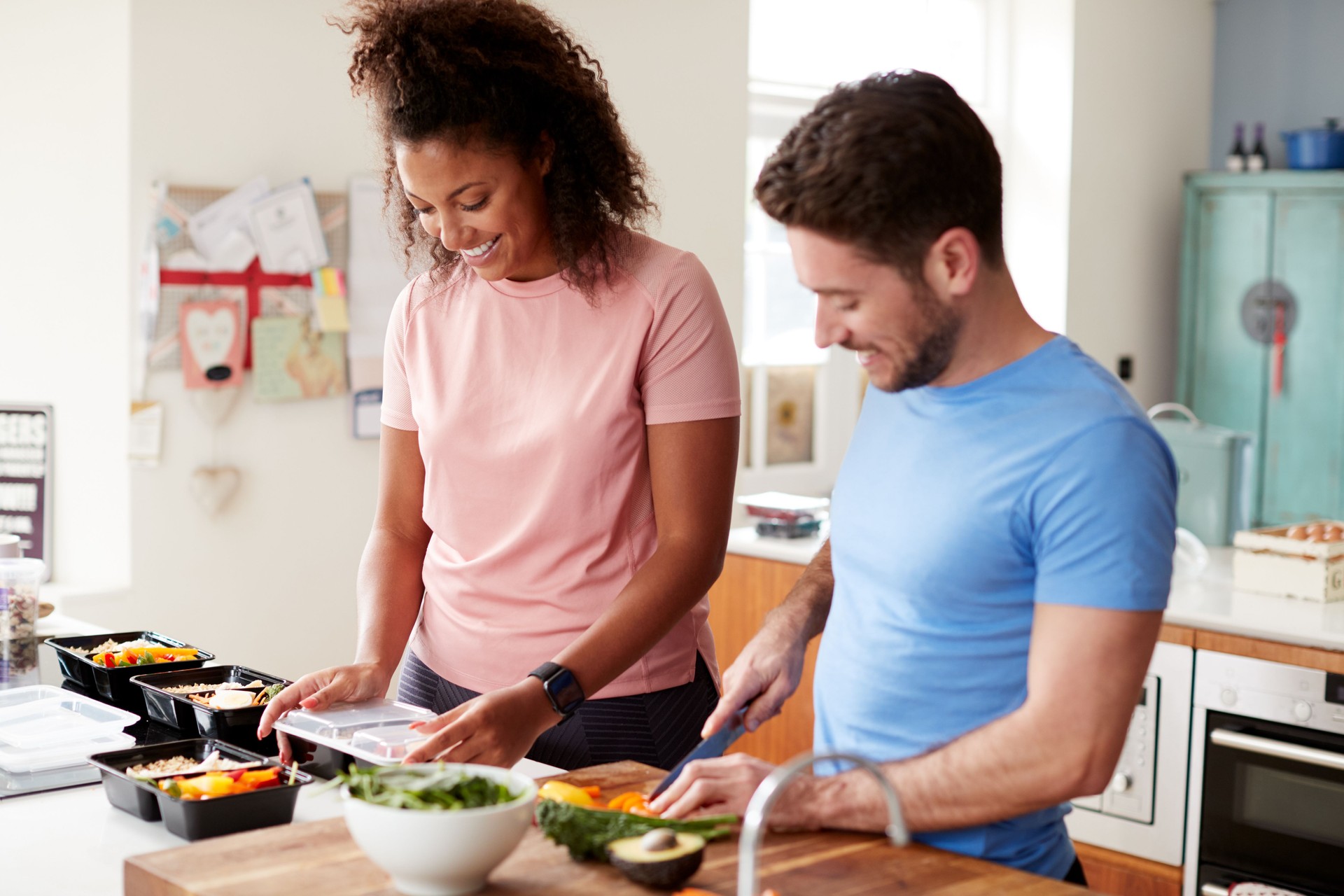 Couple Preparing Batch Of Healthy Meals At Home In Kitchen Together