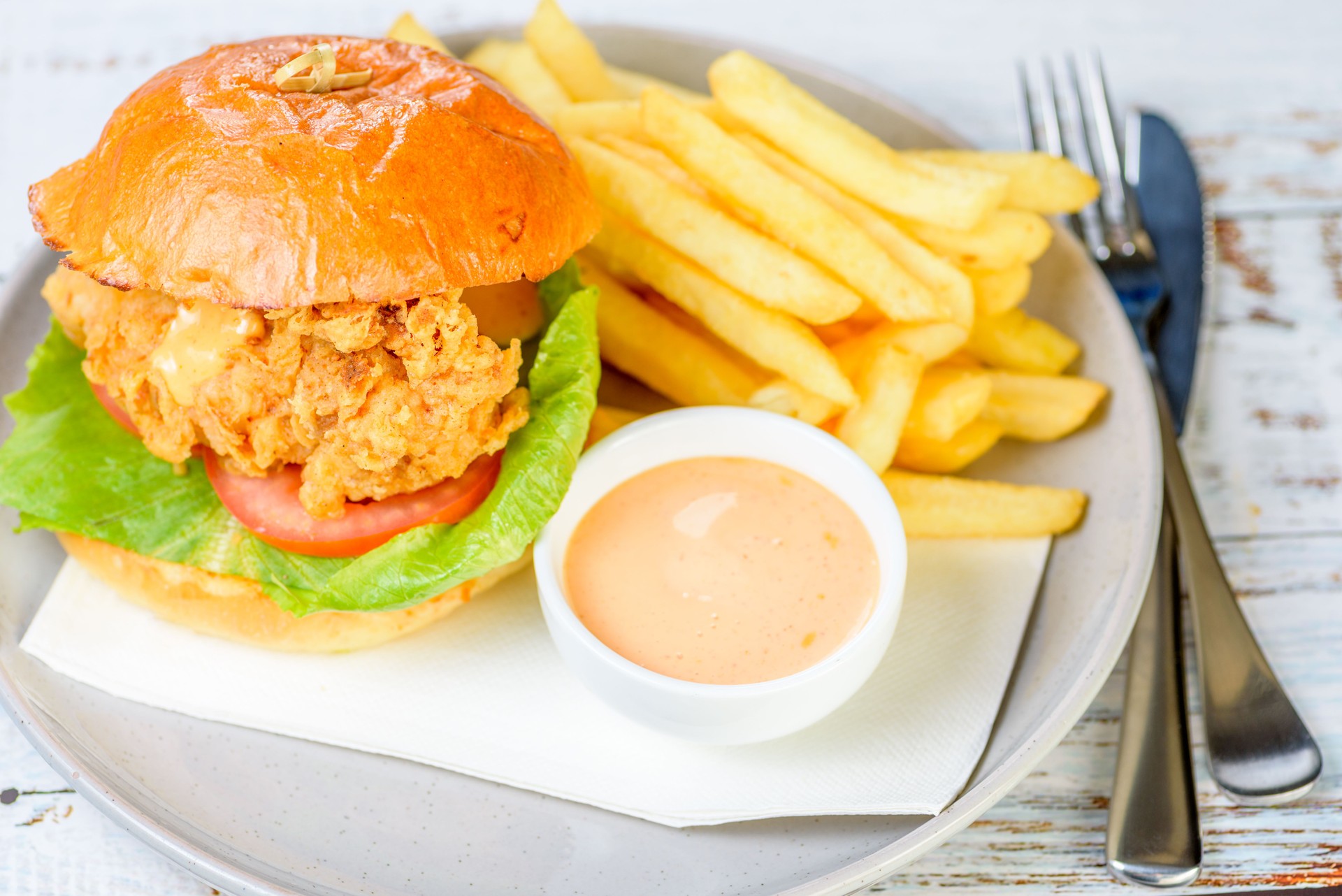 A fried chicken burger with lettuce and tomato