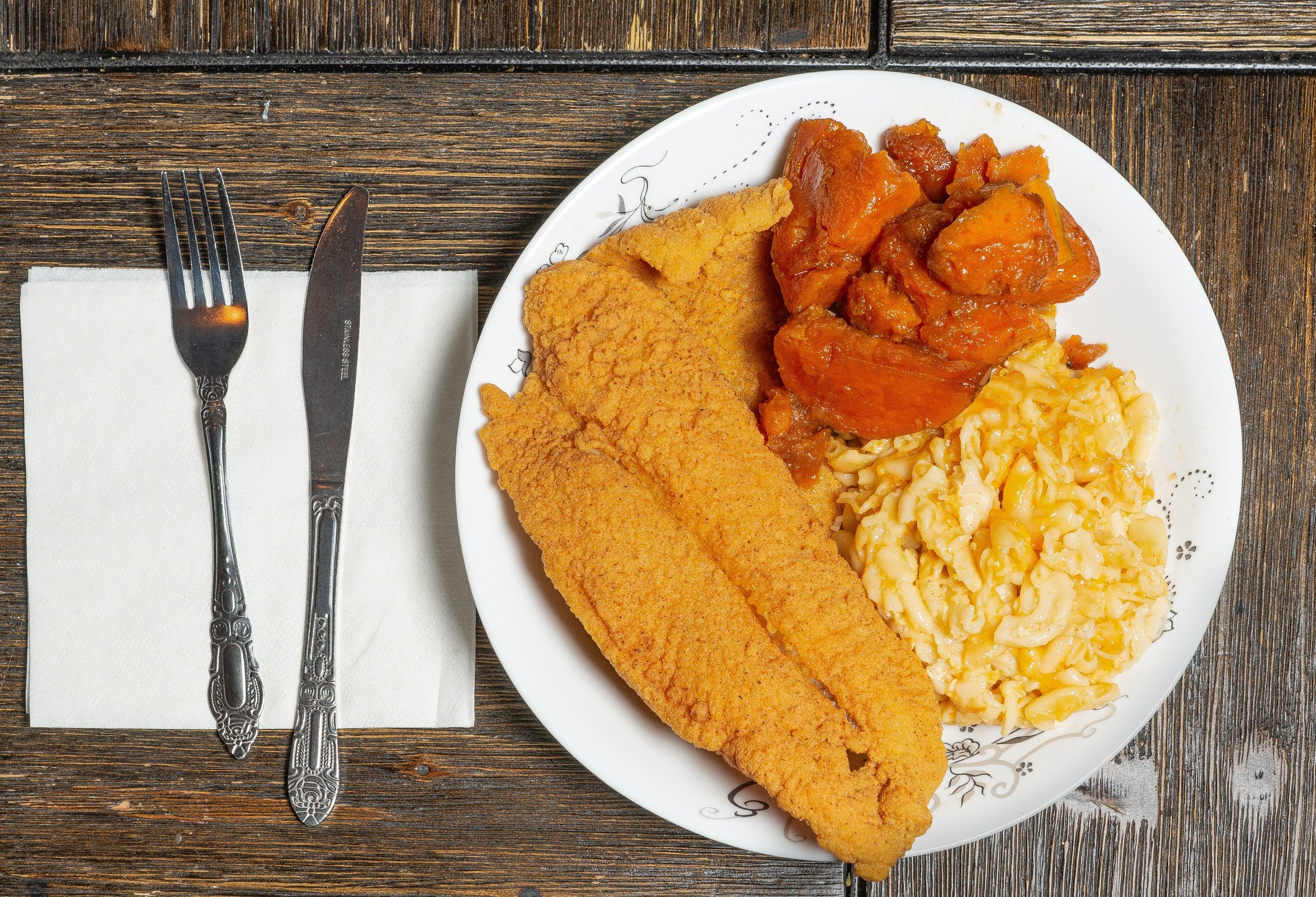 Fried fish with mac and cheese, and yams.